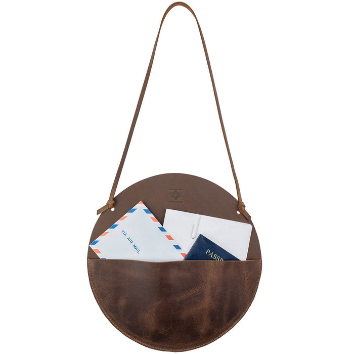 Leather At Home Circular Wall Hanger, filled with documents, letters, and envelopes. This wall file organizer is made from high-quality full grain leather, combining functionality and style in a handmade piece from La Antigua Guatemala.