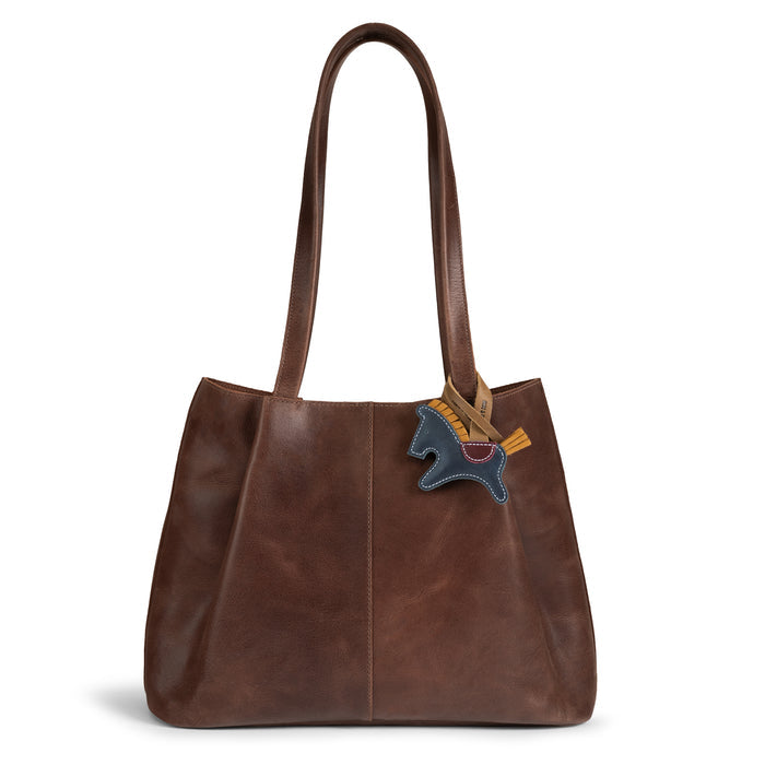 Stylish Hide & Drink Horse Bag Charm attached to a leather handbag, showcasing its unique design. This full grain leather charm is a perfect ornament for women’s fashion. Handmade in La Antigua Guatemala, it embodies artisan craftsmanship in small batch production, ideal for totes and backpacks.