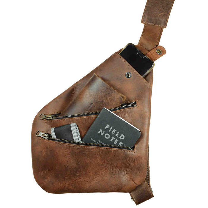 The interior of the Kidney Shoulder Bag by Hide & Drink, showcasing its organization capabilities as an Everyday Crossbody Bag. Made from Full Grain Leather, this handmade bag reflects artisan craftsmanship with hand cut and hand sewn details, proudly produced in La Antigua Guatemala & Oaxaca Mexico.