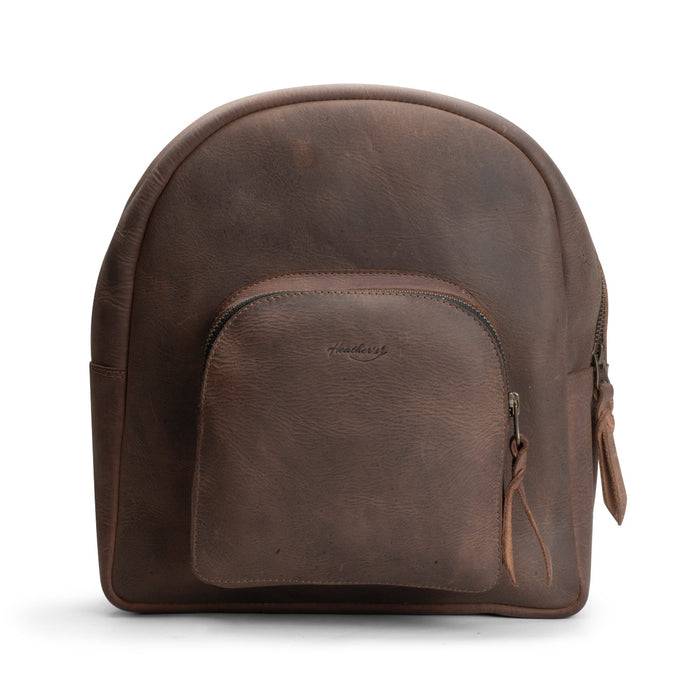 Heather's Minimalist Backpack made from full grain leather, showcasing its simple and stylish design. Ideal for carrying, organizing, and storing notebooks, makeup, and your phone, this backpack features adjustable straps and is perfect for travel. Hand cut and hand sewn by artisans in La Antigua Guatemala, it exemplifies small batch production and quality craftsmanship.