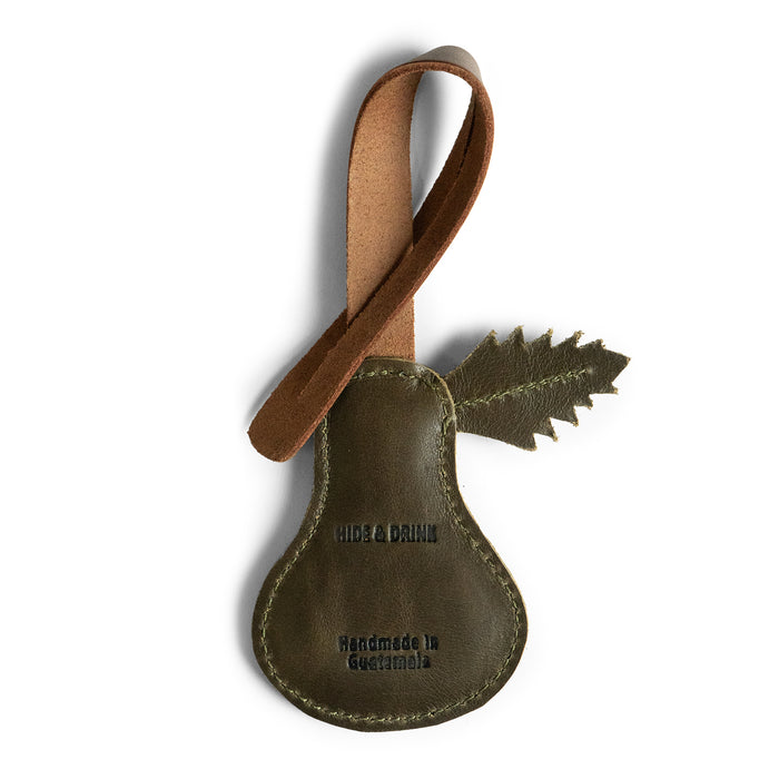 Detailed view of the Pear Bag Charm by Hide & Drink, featuring fire branded logo and leaf accent. This unique accessory is designed for handbags, purses, and backpacks, emphasizing artisan quality with full grain leather, handmade in La Antigua Guatemala & Oaxaca Mexico.