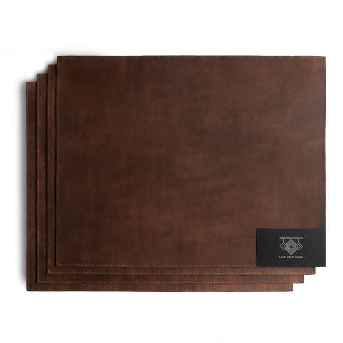 Set of 4 Rectangular Place Mats by Leather At Home, highlighting a refined collection of genuine full grain leather placemats. These rustic mats emphasize the handmade production process, including fire branding and artisan craftsmanship made in La Antigua Guatemala & Oaxaca Mexico.