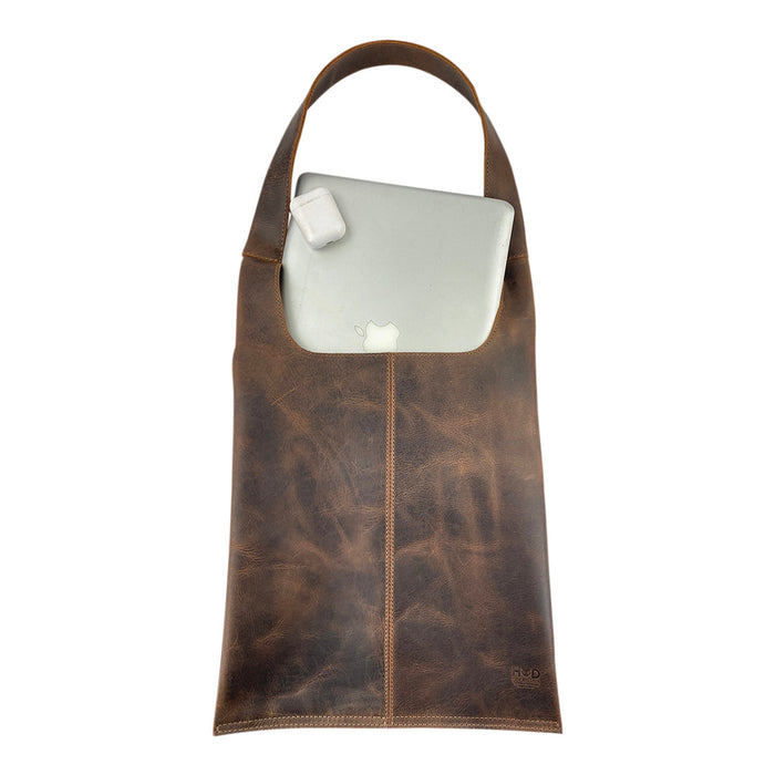 Shoulder Bag for Laptop by Hide & Drink with a laptop inside, demonstrating its spacious interior made from durable full grain leather. This messenger bag is ideal for MacBook Air/Pro owners, crafted with care in Oaxaca Mexico.