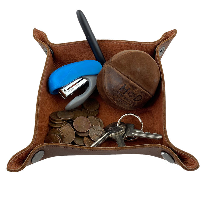 The Squared Catchall by Leather At Home filled with coins, keys, and a pen, demonstrating its perfect utility as a storage valet for everyday items. Crafted from full grain leather, it represents the essence of artisan handmade quality.