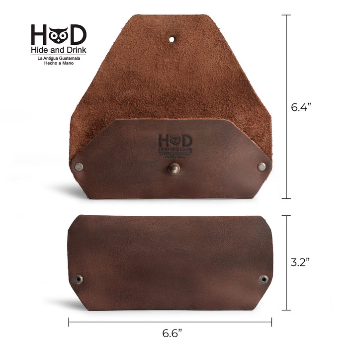 An open view of the Sunglasses Sleeve by Hide & Drink, displaying the dimensions of this minimalist sleeve case protector for eyewear. Crafted from premium full grain leather, it's a perfect accessory for sunglasses, designed for outdoor use and travel. Featuring small batch production and handmade techniques, such as hand cut, hand sewn, and fire branding, this durable item is made in La Antigua Guatemala.