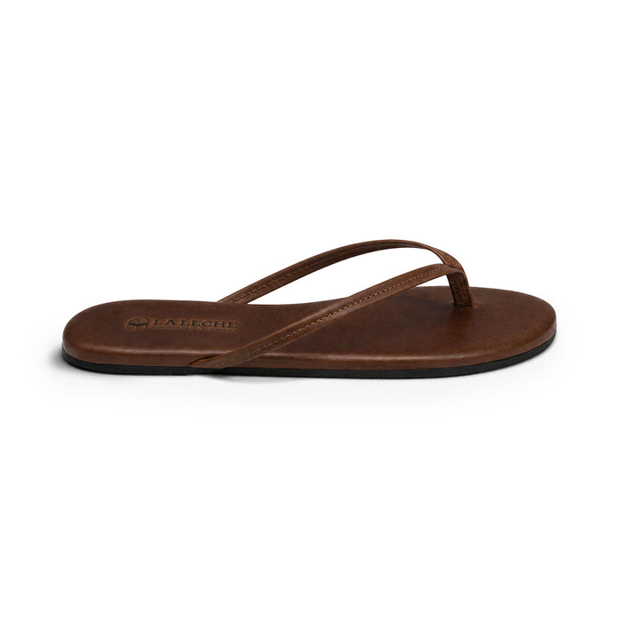 Side profile of La Leche The Solana Leather Flip Flop (Women's) showing its lightweight brown leather sole and slim straps; The Solana Leather Flip Flop (Women's), Full Grain Leather, StockyardX, Small Batch Production, Hand Cut, Hand Sewn, Fire Branded, Artisan, Handmade in La Antigua Guatemala & Oaxaca Mexico.
