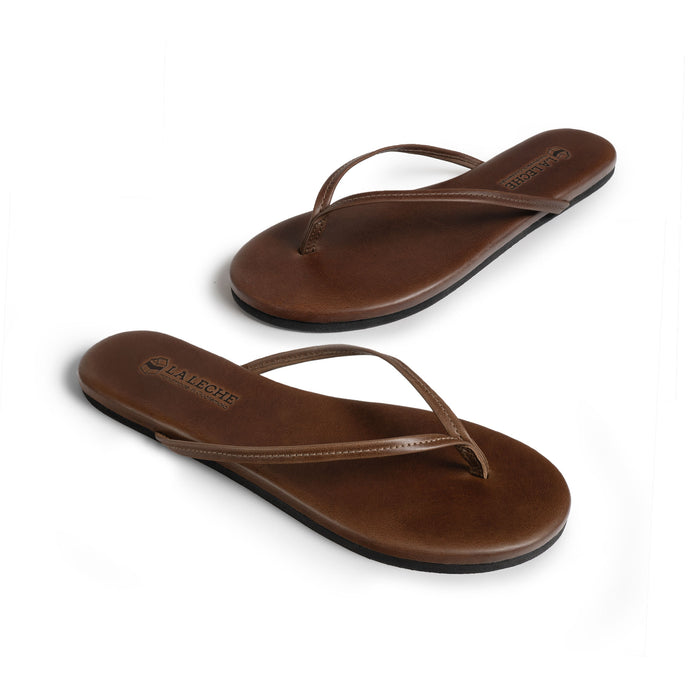 Angled pair of brown La Leche The Solana Leather Flip Flop (Women's) sandals highlighting the elegant leather straps and durable outsole; The Solana Leather Flip Flop (Women's), Full Grain Leather, StockyardX, Small Batch Production, Hand Cut, Hand Sewn, Fire Branded, Artisan, Handmade in La Antigua Guatemala & Oaxaca Mexico.