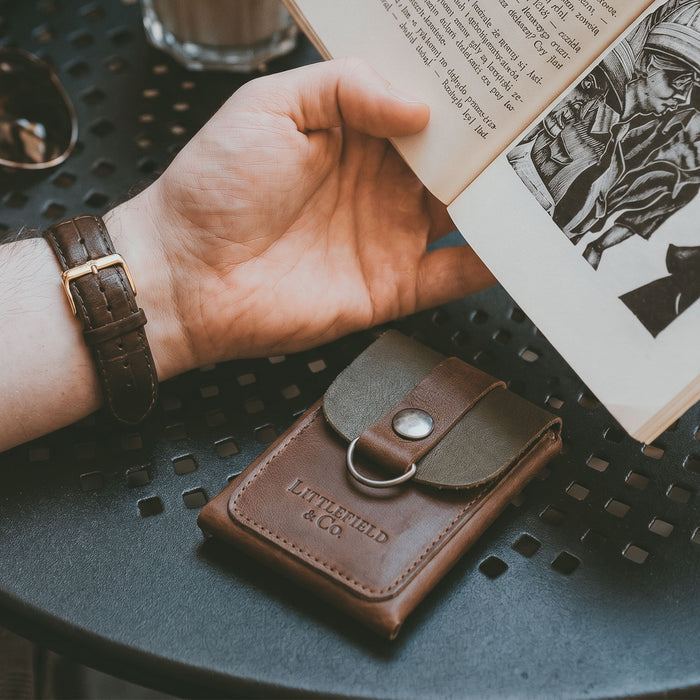Featuring the Vintage Adventure Wallet from Littlefield Chicago, this image depicts a stylish wallet in use, perfect as a classic men's wallet. The full grain leather wallet serves as an effective compact men's bill organizer and travel accessory, embodying handmade artisan craftsmanship from La Antigua Guatemala & Oaxaca Mexico.