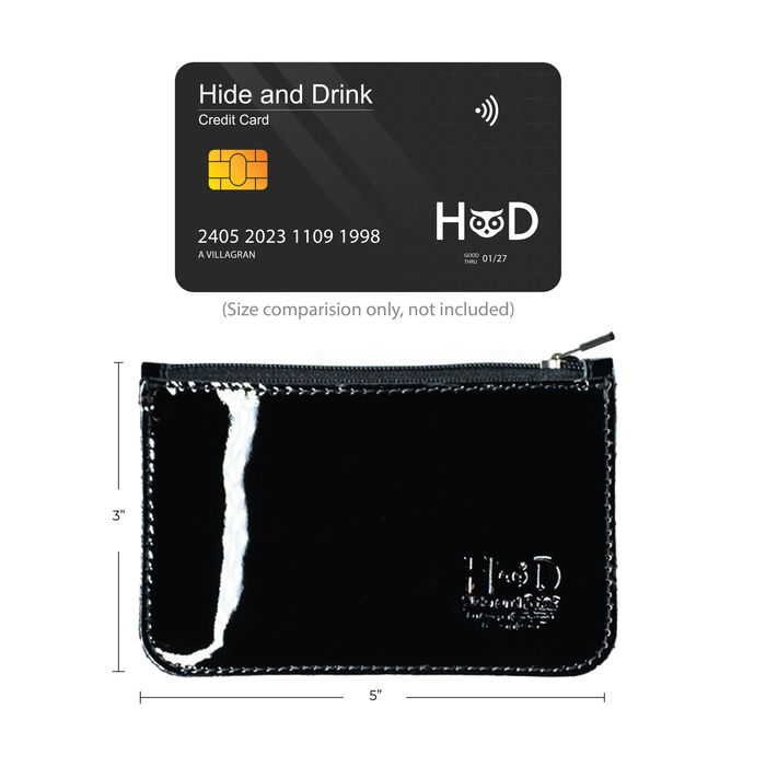 Hide & Drink Zippered Wallet next to credit cards and extra accessories, illustrating its versatility for storing essential items. This artisan handcrafted wallet in glossy black is made from full grain leather, combining function as a card case, coin organizer, and folded bills storage with small batch production from La Antigua Guatemala & Oaxaca Mexico.